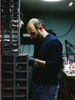 Ants craftsman making handmade jewellery in the shop